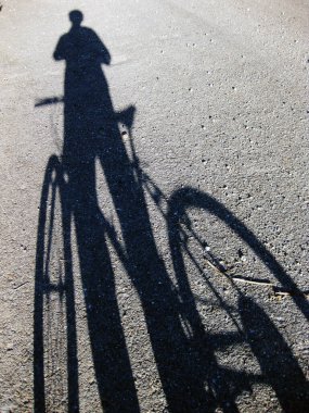 Ayakta duran bir bisikletçinin silüeti..