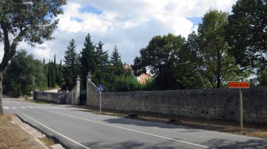 Çiftliğin taş duvarının yanındaki yol yamacında..