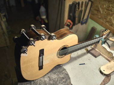 Gitarlar luthiers kol altında bir stand kurar.
