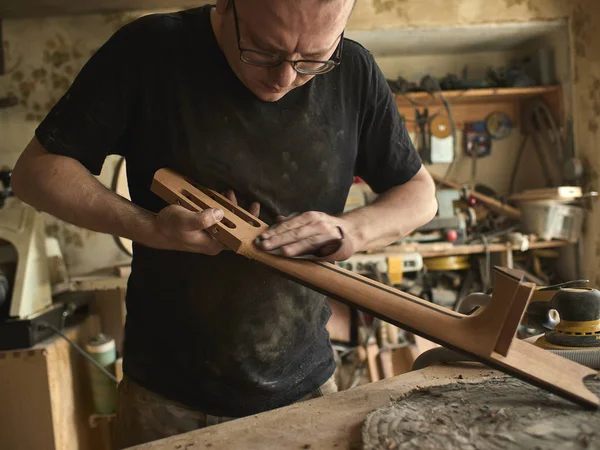 luthier klasik gitar boyun üzerinde çalışıyor.