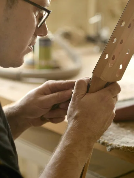 Luthier está trabajando en el cuello de la guitarra clásica . — Foto de Stock