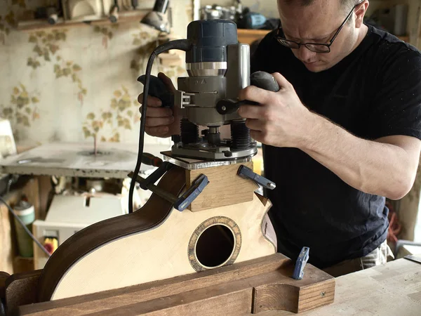 Luthier carves soundport na gitarze. — Zdjęcie stockowe