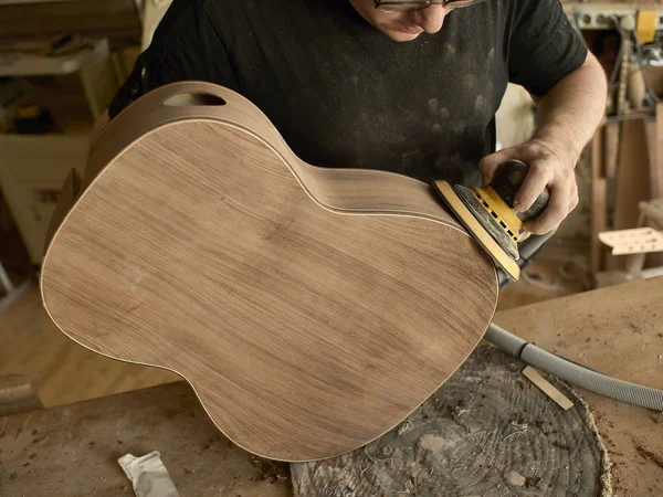 Luthier pule el cuerpo de la guitarra clásica . — Foto de Stock