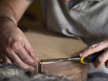 Luthier Bir gitar bağlama yükleyin. 