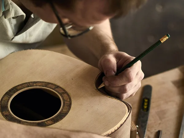 Luthier встановити прив'язку на гітарі. — стокове фото