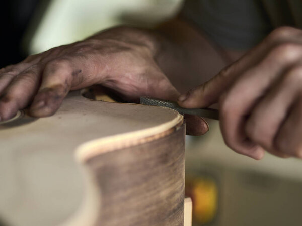 Luthier Install Binding on a guitar. 