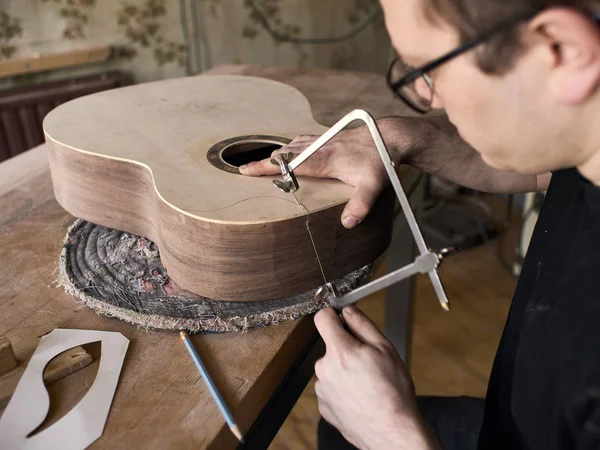 O processo de fazer um corte na guitarra clássica . — Fotografia de Stock
