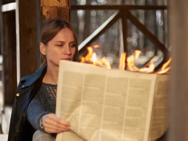 A young woman sits  and reads hot news.