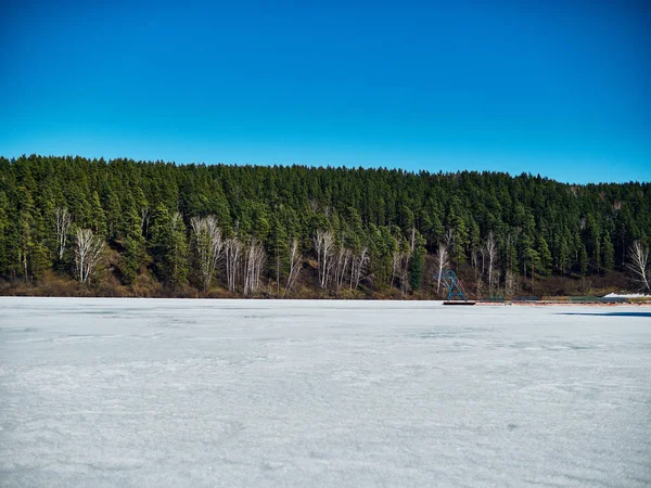 Frío paisaje siberiano de un lago tensado en el hielo . —  Fotos de Stock