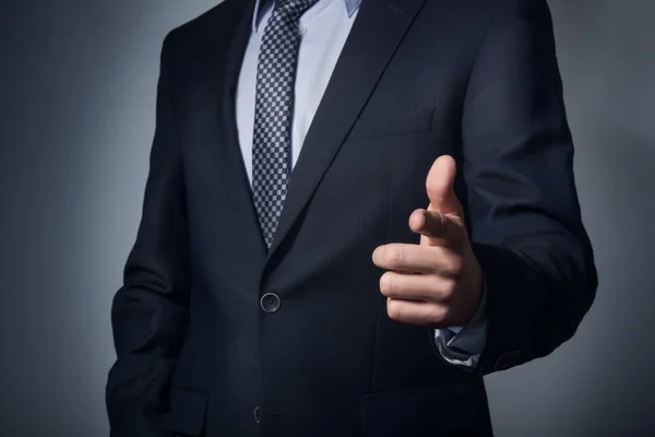 Un hombre traje de negocios señala dedo . — Foto de Stock