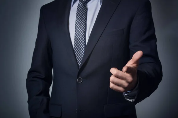 Un hombre traje de negocios señala dedo . — Foto de Stock