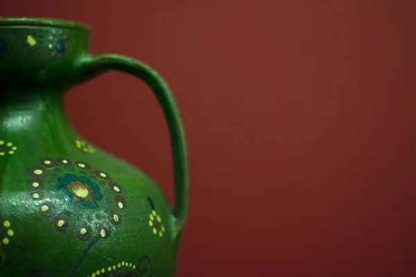 Halsen på en grön Amphoras närbild på en röd bakgrund — Stockfoto