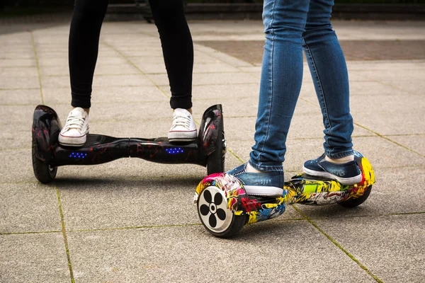 Hoverboards yakın çekim üzerinde Kadın bacaklar. 