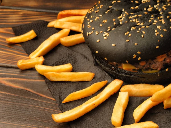 Black hamburger with French fries. — Stock Photo, Image