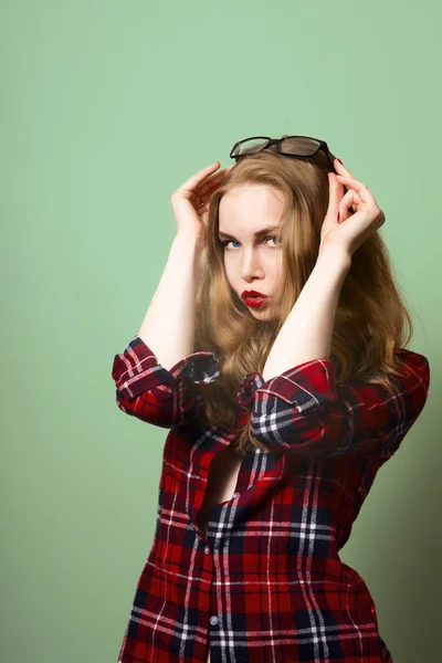 Blondes Mädchen in kariertem Hemd und Jeans. Stockbild