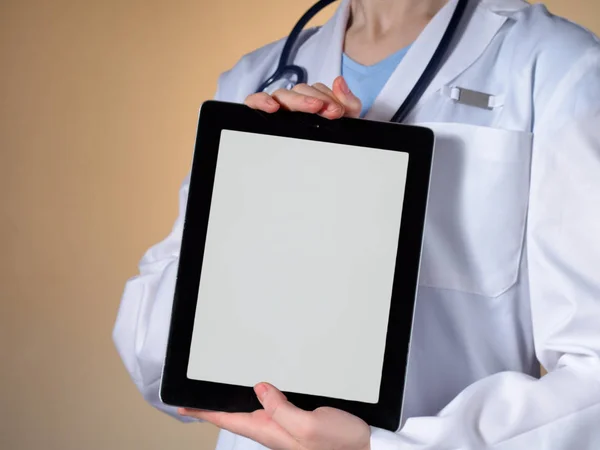 Μια γυναίκα γιατρός δείχνει μια οθόνη tablet. Royalty Free Φωτογραφίες Αρχείου