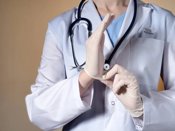 A női orvos ruhák gumi kesztyűt a kezüket. — Stock Fotó