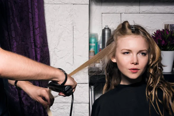 Salonda saç şekillendirme yapan genç kadın.