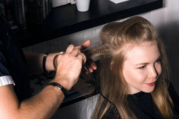 Salonda saç şekillendirme yapan genç kadın.