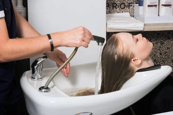 Молодая женщина моет волосы в салоне . Лицензионные Стоковые Фото