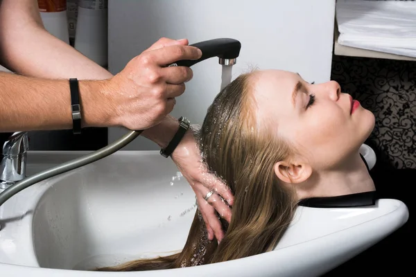Young woman washing hair in salon. Royalty Free Stock Photos