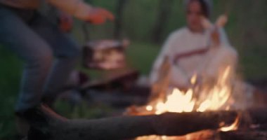 Genç bir adam taşlardan bir çaydanlık kaldırır ve kız arkadaşı için bir kupa içine su döker.