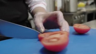 Bir Yunan salatası hazırlarken bir restoranda domates dilimleme.