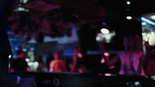 DJ at the console mixes music in a night dance club. — Stock Video