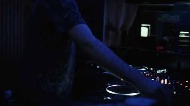 DJ at the console mixes music in a night dance club. — Stock Video