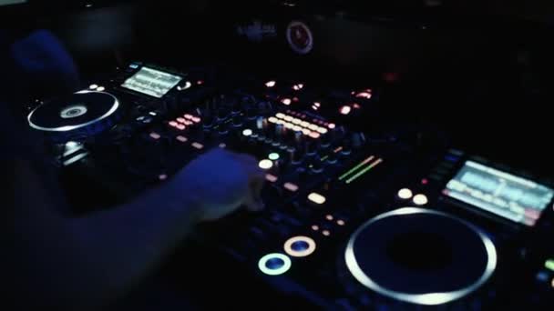 DJ på konsolen blandar musik i en natt dansklubb. — Stockvideo