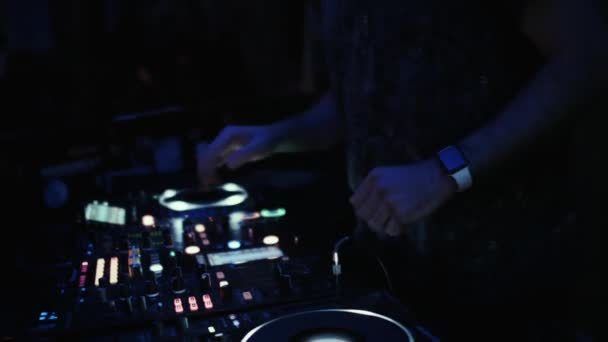 DJ at the console mixes music in a night dance club. — Stock Video