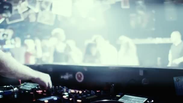 DJ at the console mixes music in a night dance club. — Stock Video