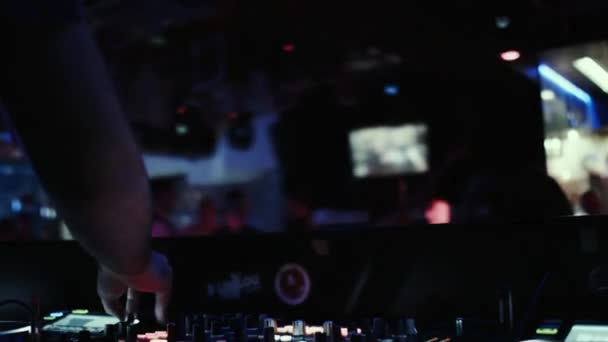 DJ at the console mixes music in a night dance club. — Stock Video