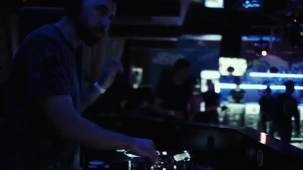 DJ op de console mengt muziek in een nacht dansclub. — Stockvideo