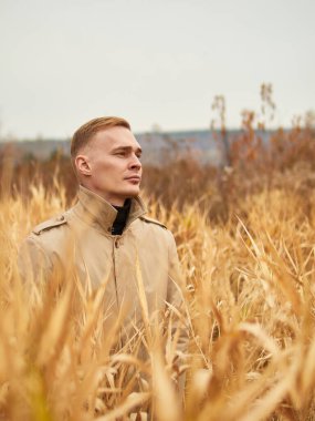 Sonbahar havası, yağmurluk giymiş genç adam yeraltında, sokak tarzı..