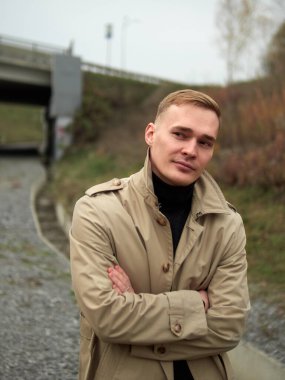 Sonbahar havası, yağmurluk giymiş genç adam yeraltında, sokak tarzı..