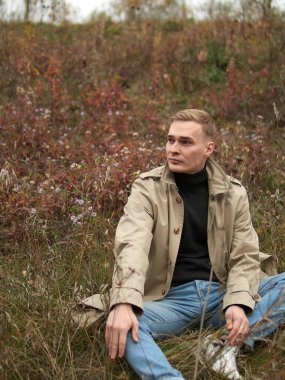 Sonbahar havası, yağmurluk giymiş genç adam yeraltında, sokak tarzı..