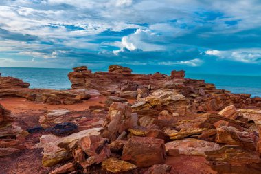 Mavi gökyüzü ve Hint Okyanusu ile dramatik kırmızı kaya oluşumu içinde belgili tanımlık geçmiş
