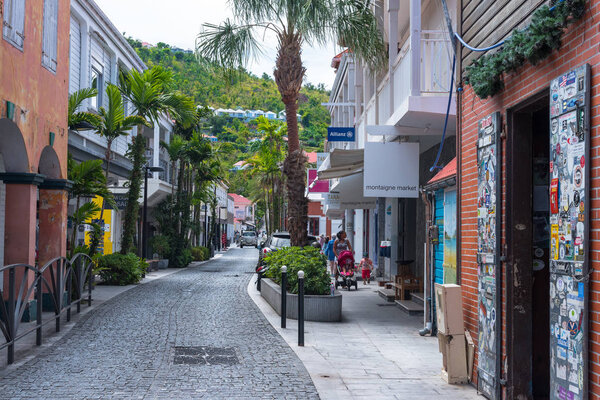Gustavia, St Barths-- April 25, 2018. A pretty cobblestone street with retail stores on either side winds its way through  Gustavia, St. Barths. Editorial Use Only.