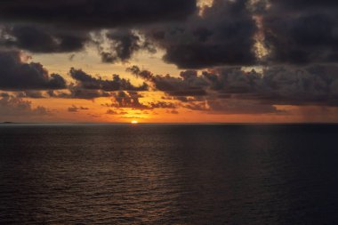 Gökyüzü turuncu döner ve güneş batarken ufukta bulutların kendisine.