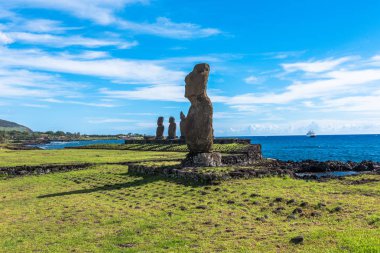 Bir satır bir Moai heykel Paskalya Adası içe seyir deniz kenarı. parlak mavi gökyüzü altında.
