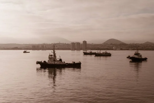 Yalan tekneler demirli olarak sis Coquimbo bağlantı noktası şehir içinde yanıyor.
