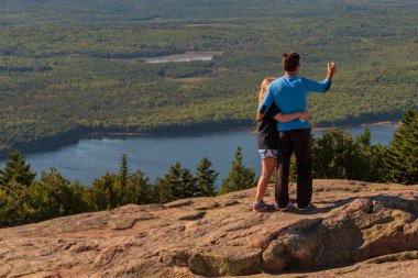 Acadia National Park, Maine, USA--September 21, 2016. A man and a woman pose for a selfie on Cadillac Mountain. clipart