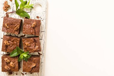 Brownie tatlı çikolata tatlı ceviz ve retro kurulu demek yapraklarda pastel bej renkli arka plan üzerinde kopya alanı ile. Lezzetli kahverengi kakao pişmiş pasta ile güzel afiş.