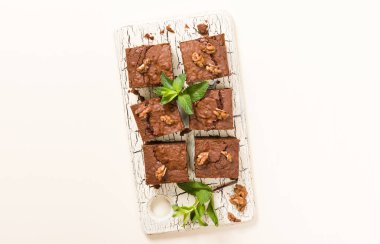 Brownie tatlı çikolata tatlı ceviz ve retro kurulu demek yapraklarda pastel bej renkli arka plan üzerinde kopya alanı ile. Lezzetli kahverengi kakao pişmiş pasta ile güzel afiş.