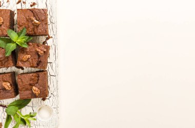 Brownie tatlı çikolata tatlı ceviz ve retro kurulu demek yapraklarda pastel bej renkli arka plan üzerinde kopya alanı ile. Lezzetli kahverengi kakao pişmiş pasta ile güzel afiş.