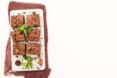 Brownie tatlı çikolata tatlı ceviz ve retro kurulu demek yapraklarda pastel bej renkli arka plan üzerinde kopya alanı ile. Lezzetli kahverengi kakao pişmiş pasta ile güzel afiş.