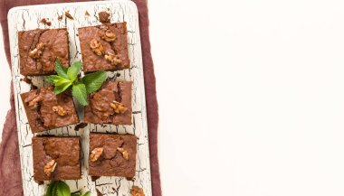 Brownie tatlı çikolata tatlı ceviz ve retro kurulu demek yapraklarda pastel bej renkli arka plan üzerinde kopya alanı ile. Lezzetli kahverengi kakao pişmiş pasta ile güzel afiş.