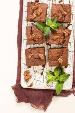 Brownie tatlı çikolata tatlı ceviz ve retro kurulu demek yapraklarda pastel bej renkli arka plan üzerinde kopya alanı ile. Lezzetli kahverengi kakao pişmiş pasta ile güzel afiş.