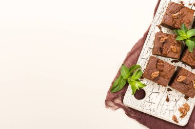 Brownie tatlı çikolata tatlı ceviz ve retro kurulu demek yapraklarda pastel bej renkli arka plan üzerinde kopya alanı ile. Lezzetli kahverengi kakao pişmiş pasta ile güzel afiş.